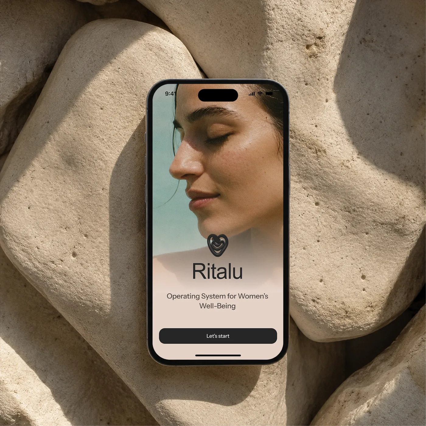 Ritalu app shown on a phone resting on stone